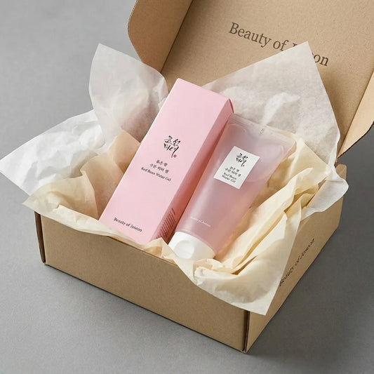 Angle : Vue oblique dynamique à mi-hauteur.  Scène : Le duo de l'image est présenté à l'intérieur d'un coffret de livraison premium e-commerce en carton kraft beige ouvert. Le produit est niché au milieu d'une superposition esthétique de papiers de soie froissés de deux couleurs : l'un blanc laiteux, l'autre crème.  Éclairage : Surface de studio mate contemporaine grise. Éclairage uniforme et très lumineux de studio, mettant en valeur l'aspect cadeau exclusif et personnalisé du produit. (gemini-3.1-flash-im
