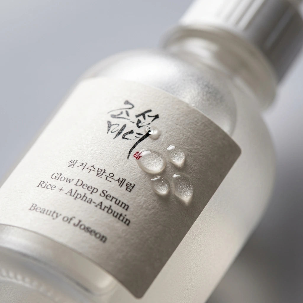 Angle : Très gros plan  Très gros plan sur le flacon Beauty of Joseon Glow Deep Serum, mettant en valeur la texture du verre dépoli, les reflets lumineux et quelques gouttes de sérum sur la surface. Profondeur de champ très faible, photographie macro ultra réaliste. (gemini-3.1-flash-image-preview)