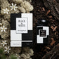L'idée : Remplacer le fond de studio par un sol forestier bicolore et texturé.  Le Prompt à copier :  Vue de dessus (flat-lay) artistique et forestière. Le flacon et sa boîte à damier "BLACK & WHITE" sont posés côte à côte sur un sol forestier divisé naturellement : une moitié est recouverte de mousse blanche islandaise séchée (lichen), l'autre moitié de terreau noir profond et d'écorces sombres. Les ingrédients du parfum (fleurs blanches, éclats de bois sombre) sont parsemés comme s'ils avaient poussé là. 