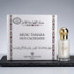 Un plan moyen net et frontal du parfum 'MUSC TAHARA OUD CACHEMIRE' s'inspirant de image_54.jpg. Le grand coffret blanc carré aux frises rouges et lettrages noirs est posé à la verticale sur une dalle texturée d'ardoise noire mate. Juste à côté, à droite, le petit flacon transparent au jus blanc laiteux et pailleté se dresse fièrement, coiffé de son bouchon sphérique en or poli miroir. Éclairage de studio blanc, doux et diffus, éliminant les ombres dures. Style publicitaire épuré et luxueux. (gemini-3.1-flas