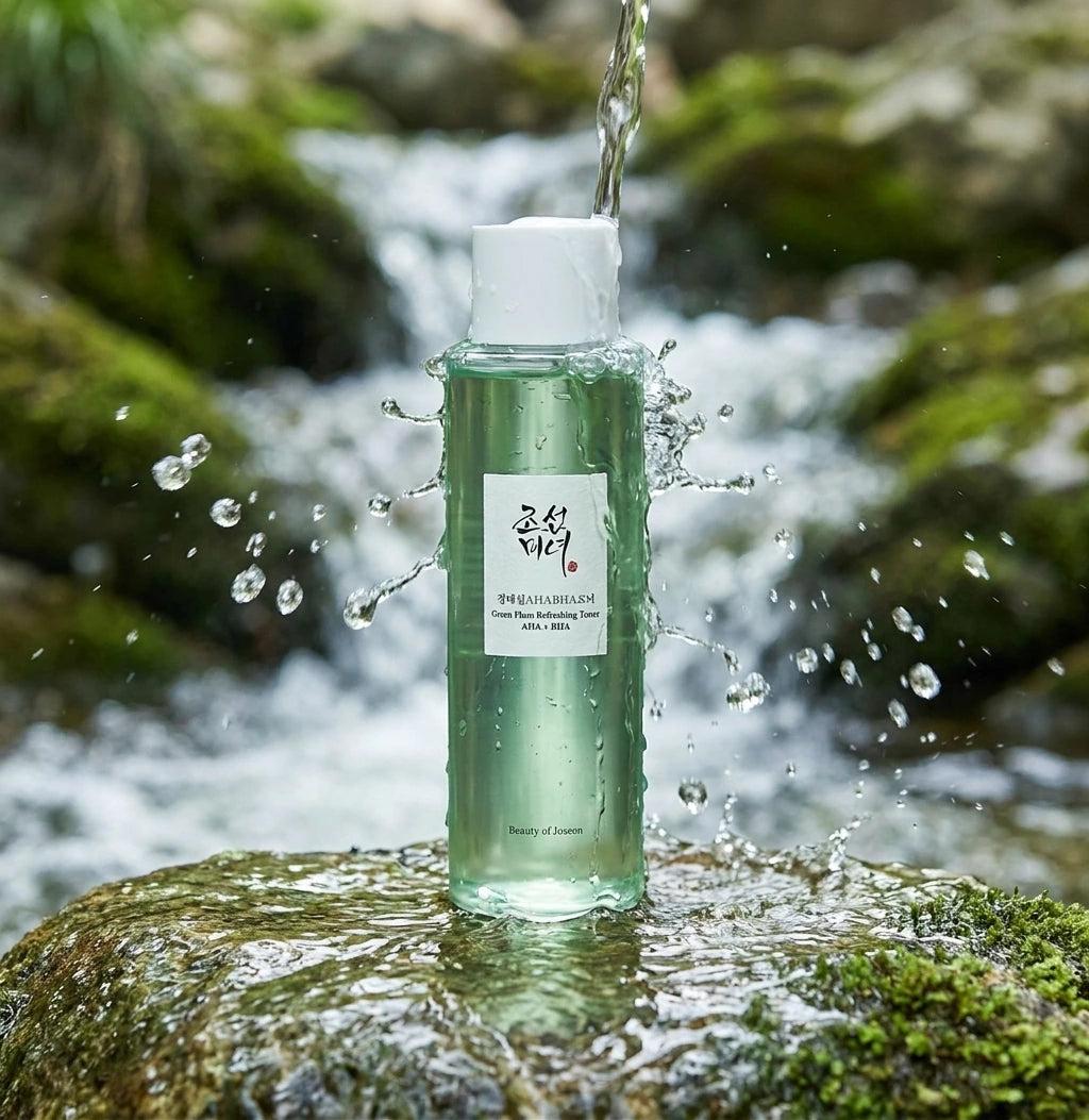 Angle légèrement en contre-plongée  Beauty of Joseon Green Plum Refreshing Toner placed on wet stone beneath a gentle waterfall, crystal clear water splashing naturally around the bottle, realistic droplets frozen in motion, premium skincare campaign, refreshing hydration concept, ultra realistic lighting, luxury cosmetic photography. (gemini-3-pro-image-preview)