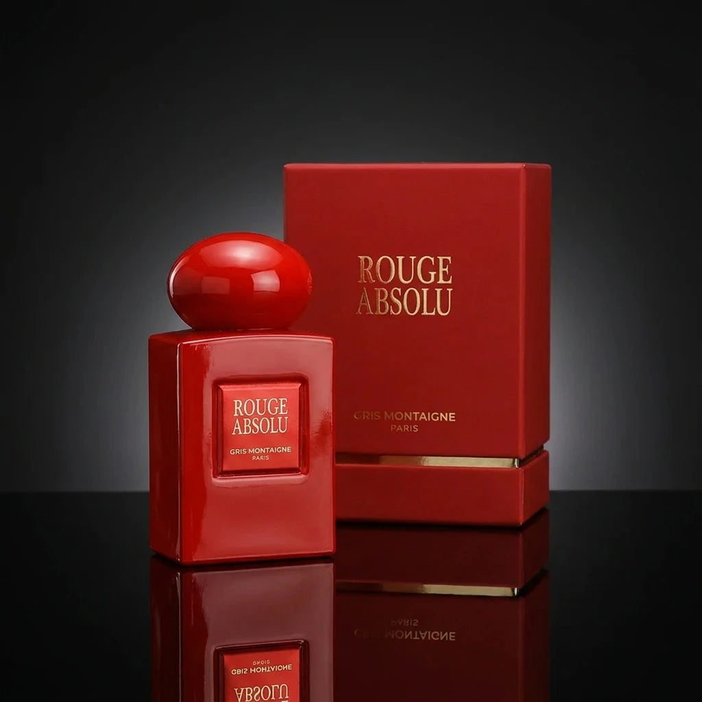Concept de shooting : Une mise en scène studio classique et intemporelle de la haute parfumerie.  Le Prompt à copier :  Une photographie publicitaire de haute parfumerie en studio. La boîte de luxe rouge fermée "ROUGE ABSOLU" est installée au second plan. Juste devant elle, au premier plan, le flacon rouge laqué au bouchon sphérique brillant trône fièrement sur un sol miroir noir hautement réfléchissant. Le fond est un dégradé subtil de gris foncé à noir mat. Un éclairage de studio précis crée un halo lumin