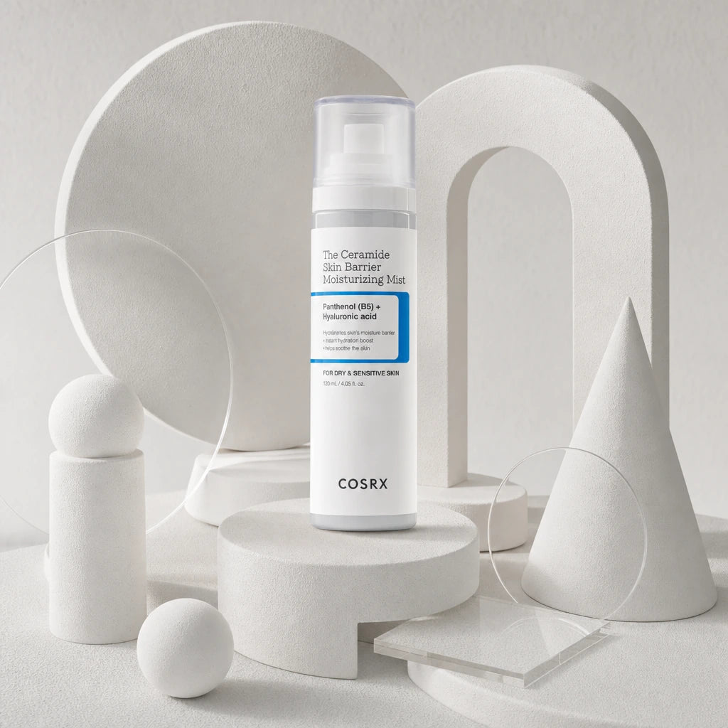 Une composition artistique et texturée au format carré 1200x1200px. Le flacon de image_d75062.png est joliment niché au centre d'un agencement de plusieurs formes géométriques abstraites en plâtre blanc mat (cercles, arches, cônes) et de petites plaques en verre acrylique transparent. Une lumière latérale et douce met en valeur le relief des éléments blancs, contrastant élégamment avec le bandeau bleu vif du packaging COSRX. (gpt-image-2)